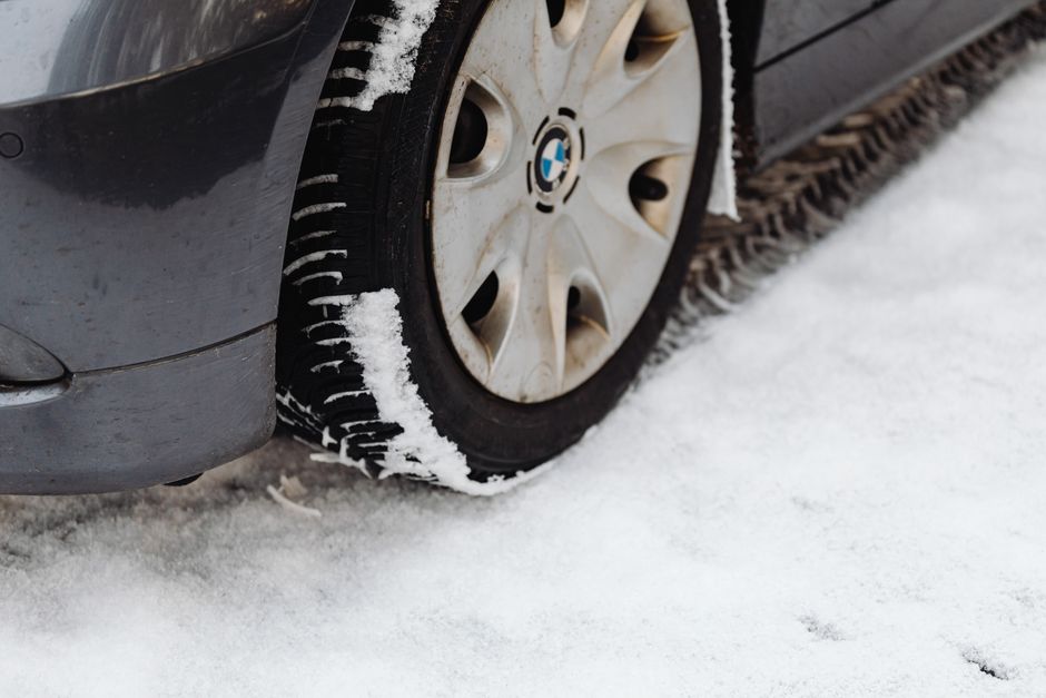 Technician checking tire tread depth during rotation